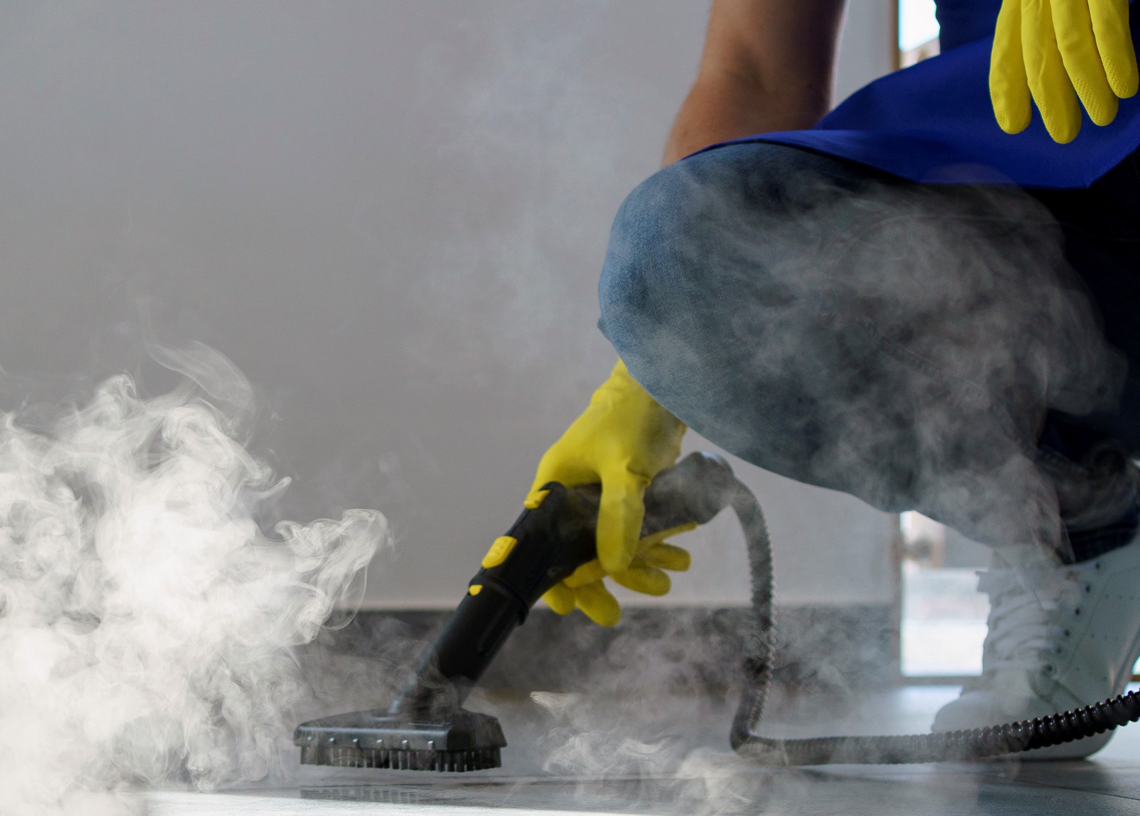 Steam cleaning floor with visible steam